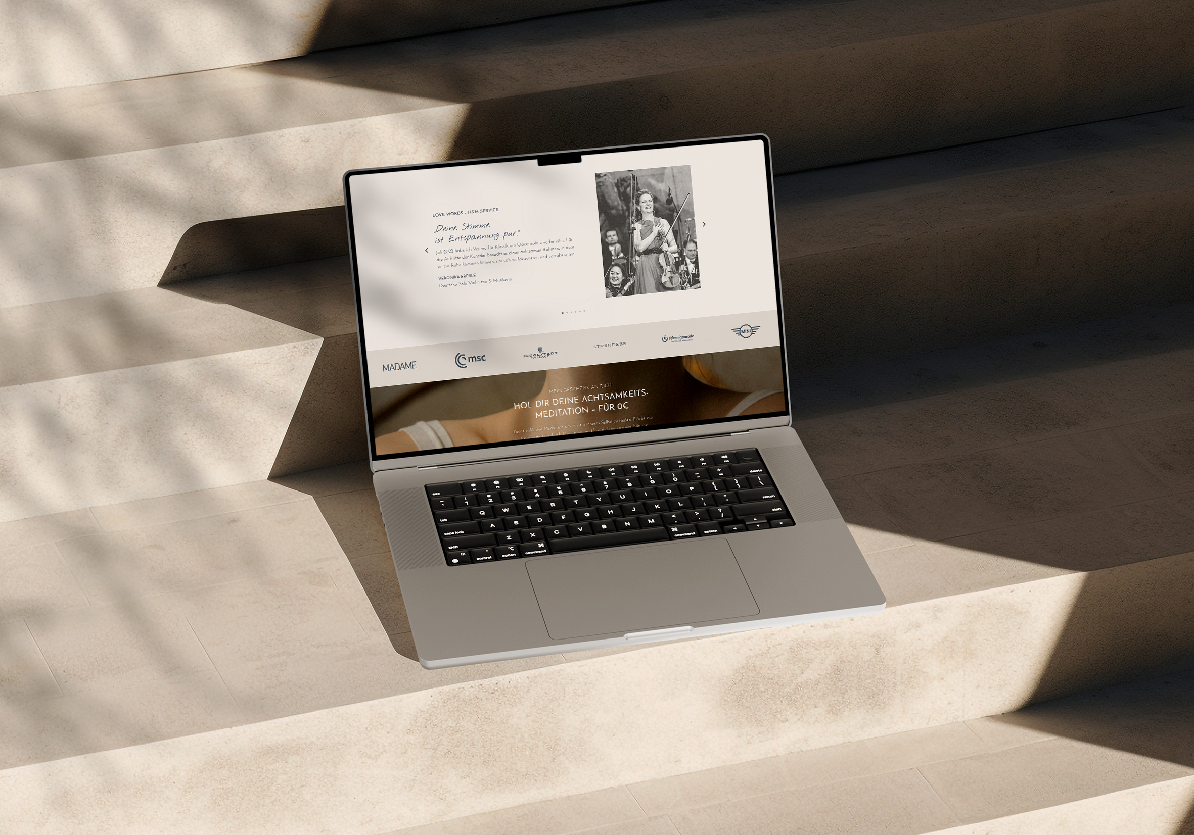 Mockup einer Website für ein Achtsamkeits- und Musik-Branding-Projekt. Laptop auf Treppen mit sanftem Licht und Schatten. Hochwertiges Webdesign für einen ganzheitlichen, eleganten Markenauftritt.